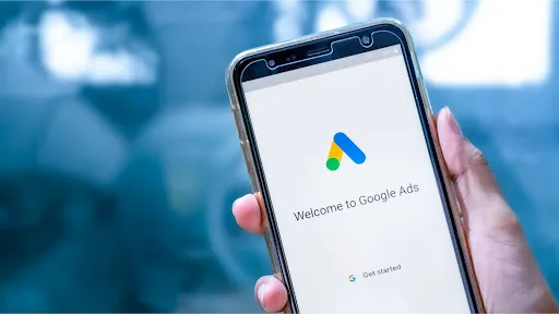 Someone holding a phone that says "welcome to Google ads."